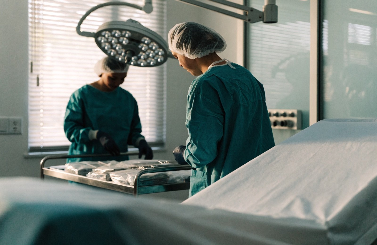 Zwei Personen in OP-Kleidung bereiten im Operationssaal Instrumente vor