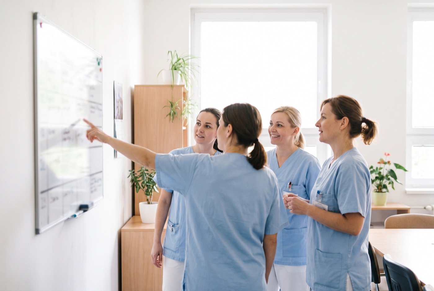Team vor der Dienstplantafel zu Schichtbeginn