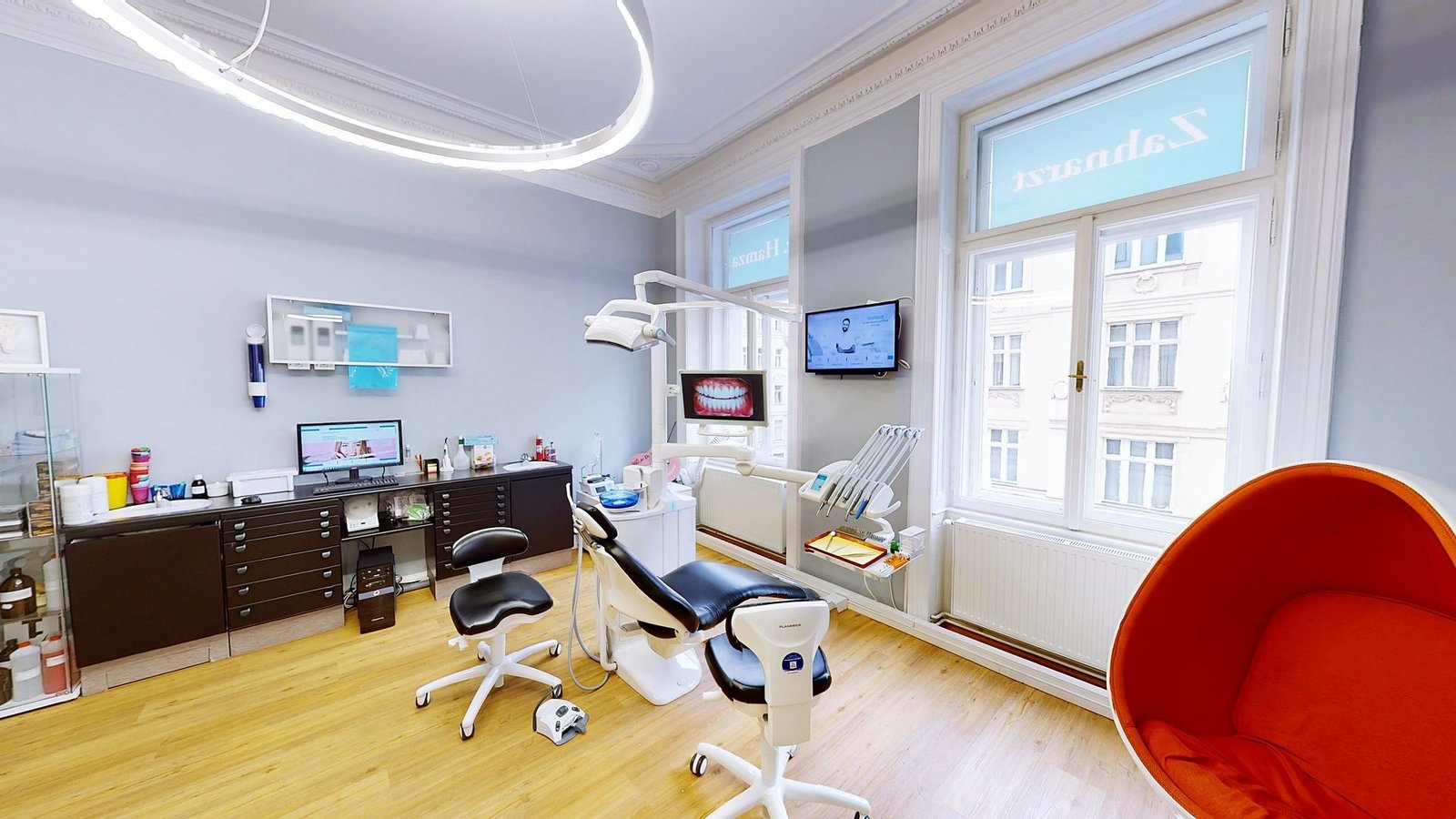 Behandlungsraum der Ordination: Wiener Altbau mit Stuckdecke, Ringleuchte und modernem Behandlungsstuhl